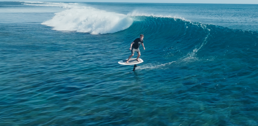Surfer foilt eine Welle mit dem Manta Foils TakOff Foil Assist