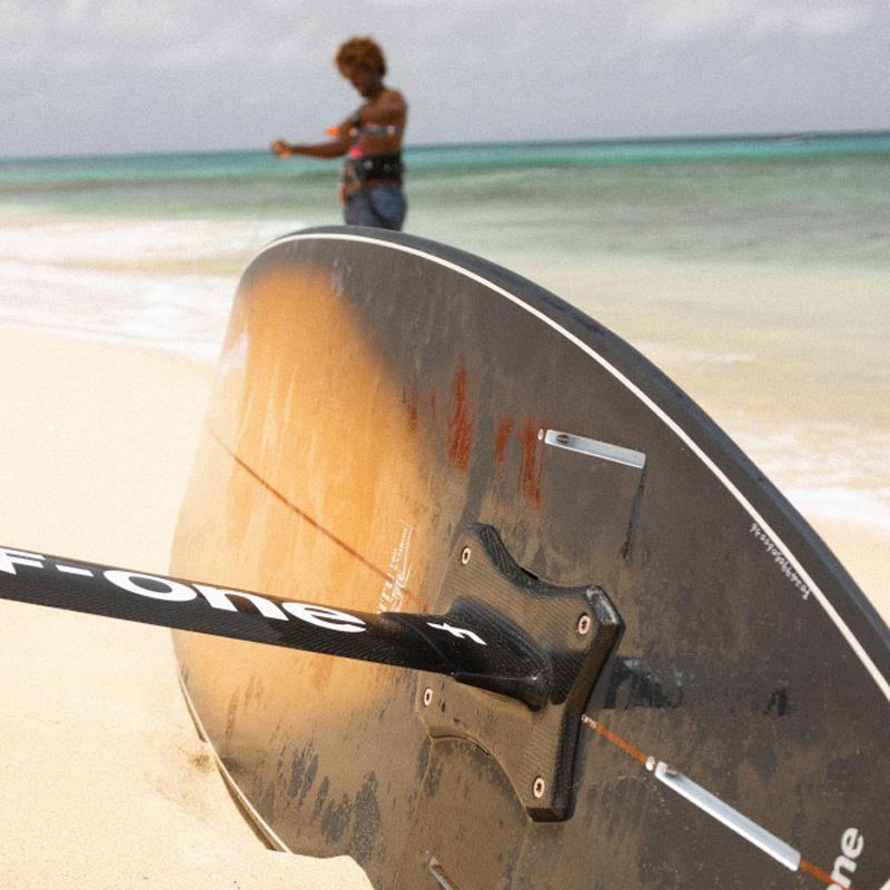 Nahaufnahme am Strand vom Mitu Foil Bamboo und Carbon Mast an der Foil Halterung des Boards
